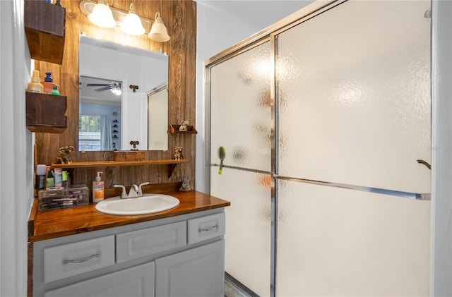 bathroom with a shower with door and vanity