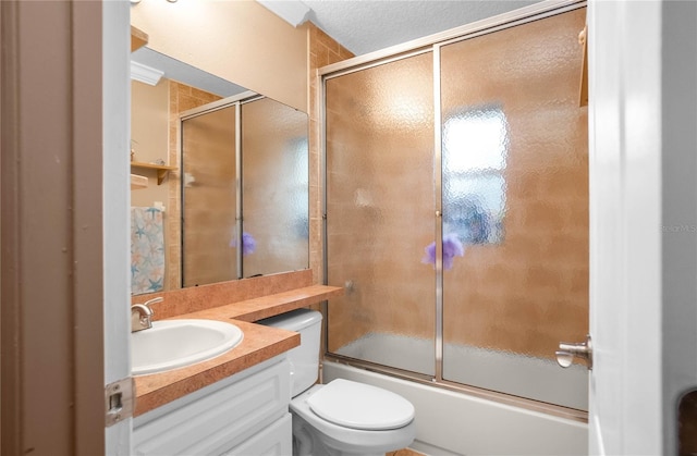 full bathroom with toilet, a textured ceiling, bath / shower combo with glass door, and vanity