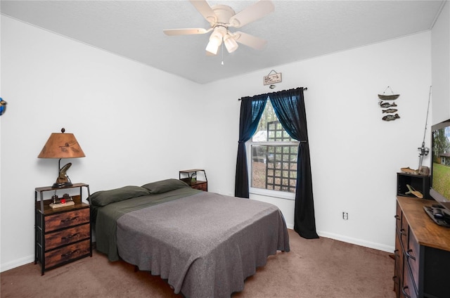 carpeted bedroom featuring ceiling fan and a textured ceiling