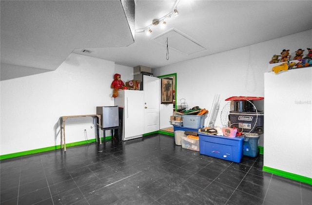 interior space featuring white refrigerator and rail lighting