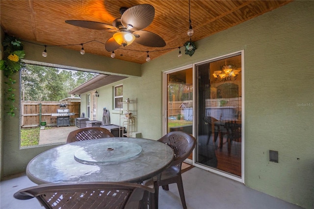 sunroom / solarium featuring a wealth of natural light, ceiling fan, and wood ceiling