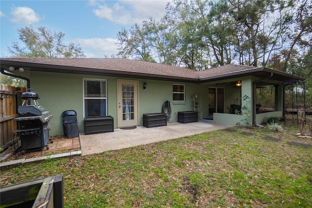 back of house with a patio area and a lawn