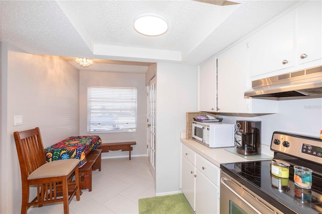 kitchen featuring a tray ceiling, stainless steel electric range, a textured ceiling, and white cabinets