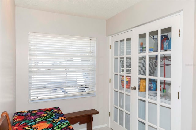 doorway to outside featuring french doors and a textured ceiling