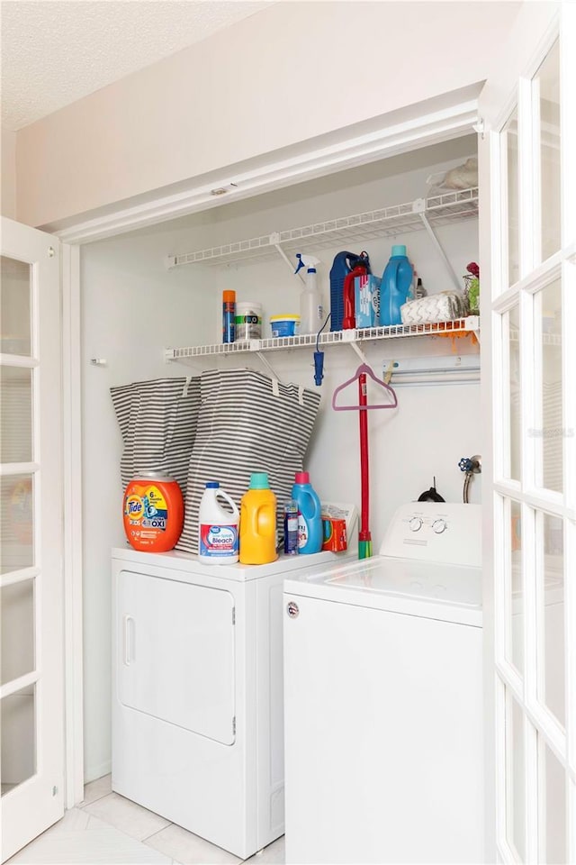 laundry room with independent washer and dryer and a textured ceiling