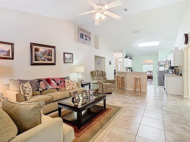 tiled living room with lofted ceiling and ceiling fan