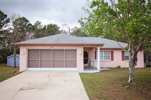 single story home with a front lawn, an attached garage, driveway, and stucco siding