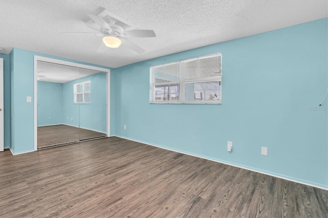 spare room featuring ceiling fan, a textured ceiling, baseboards, and wood finished floors