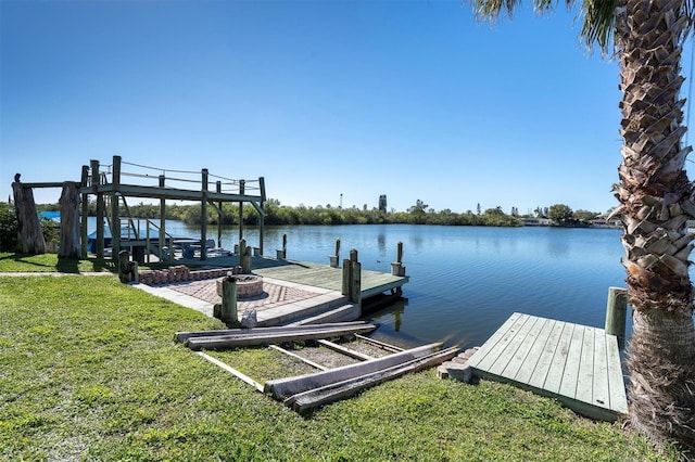 view of dock with a water view and a yard