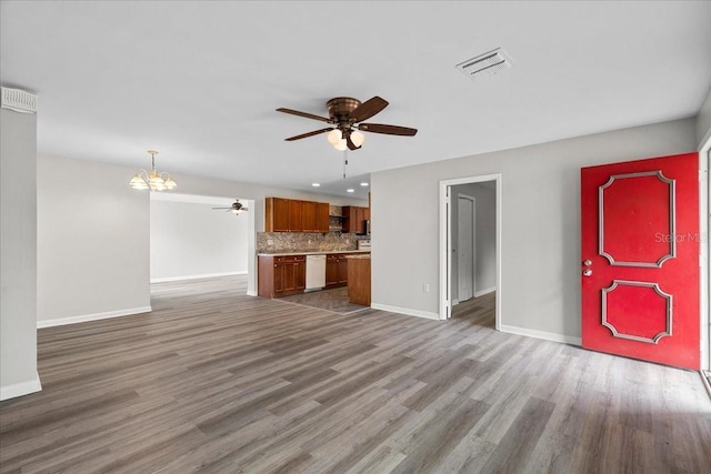 unfurnished living room with hardwood / wood-style flooring and ceiling fan with notable chandelier