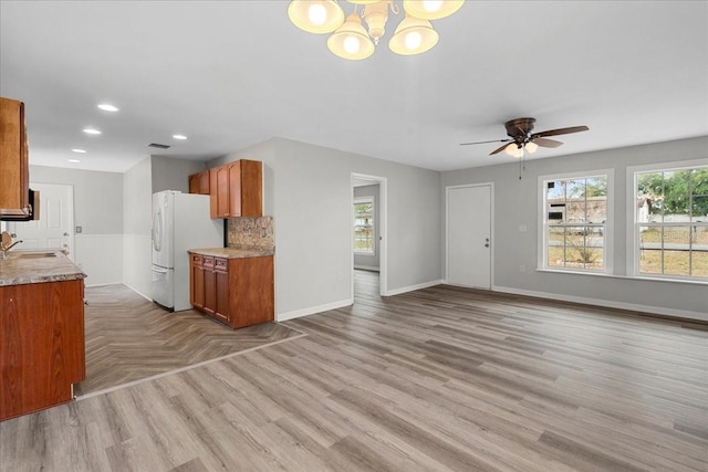 kitchen with sink, white fridge, plenty of natural light, and light hardwood / wood-style flooring