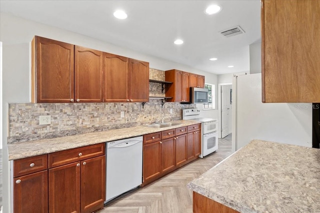 kitchen featuring sink, white appliances, light parquet flooring, and decorative backsplash