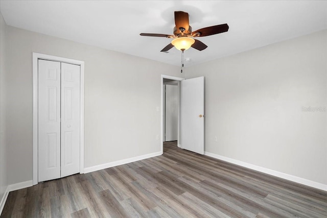 unfurnished bedroom featuring light hardwood / wood-style floors, a closet, and ceiling fan