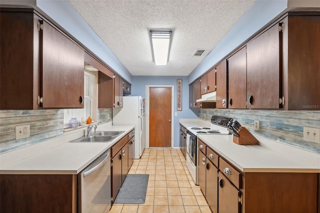 kitchen featuring light tile patterned flooring, sink, white appliances, and backsplash