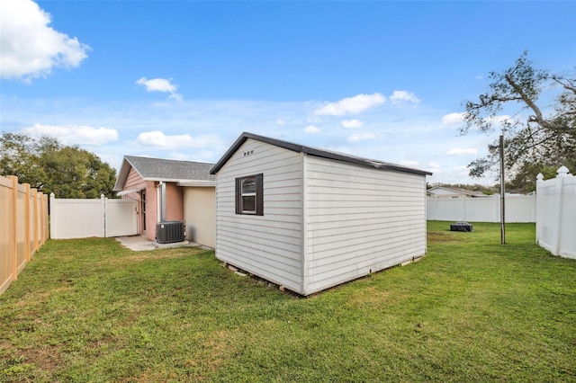 exterior space featuring a yard, a storage unit, and central air condition unit