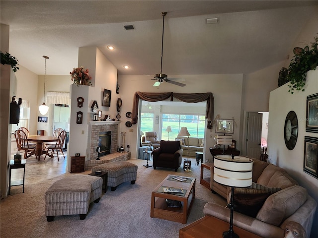 carpeted living area featuring high vaulted ceiling, visible vents, a fireplace, and ceiling fan