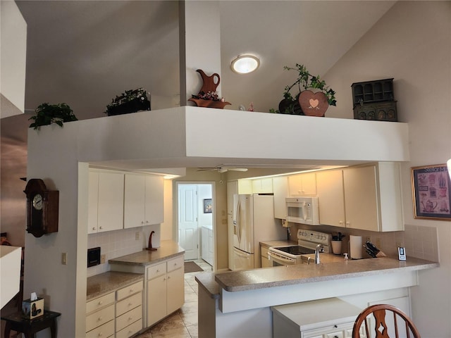 kitchen featuring white appliances, light countertops, and a peninsula