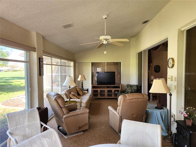 carpeted living area featuring lofted ceiling, ceiling fan, a textured ceiling, and visible vents