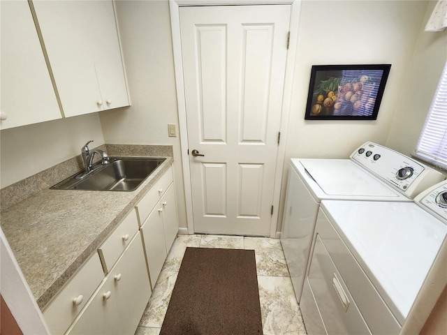 washroom with washer and dryer, cabinet space, and a sink