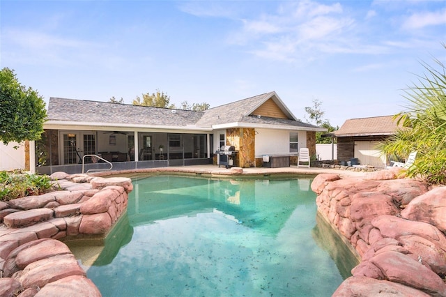 exterior space with a fenced in pool, a sunroom, and grilling area