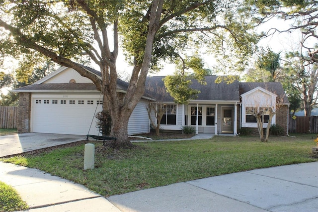 ranch-style house with a garage, a front yard, concrete driveway, and brick siding