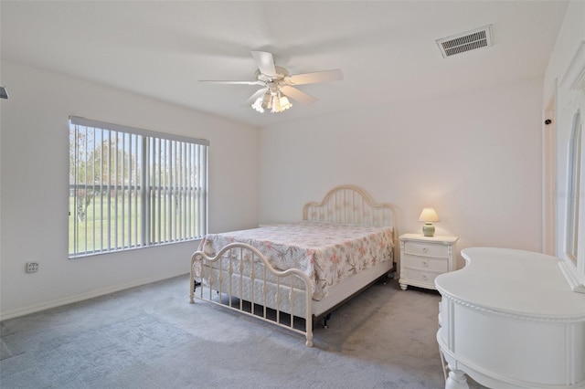 carpeted bedroom featuring a ceiling fan, visible vents, and baseboards