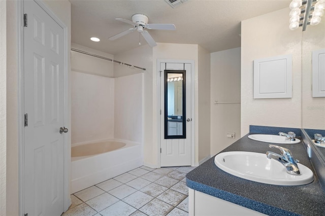 bathroom featuring double vanity, a ceiling fan, tub / shower combination, a sink, and tile patterned floors