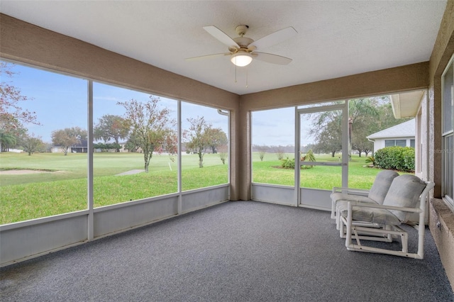 unfurnished sunroom with a ceiling fan