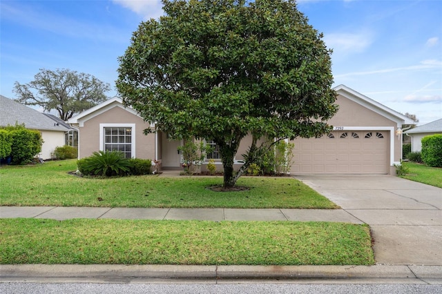 view of front of property featuring an attached garage, a front lawn, and stucco siding