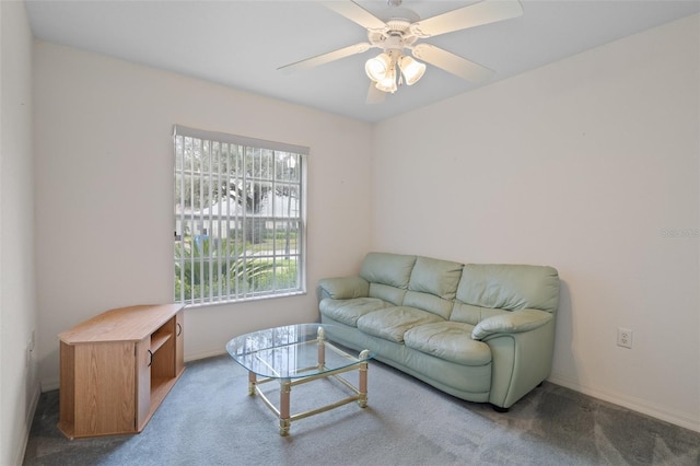 carpeted living area with a ceiling fan and baseboards