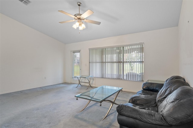 living area with lofted ceiling, visible vents, baseboards, a ceiling fan, and carpet