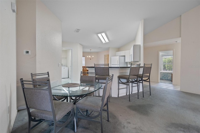 dining area featuring washer / dryer, visible vents, a notable chandelier, and light colored carpet