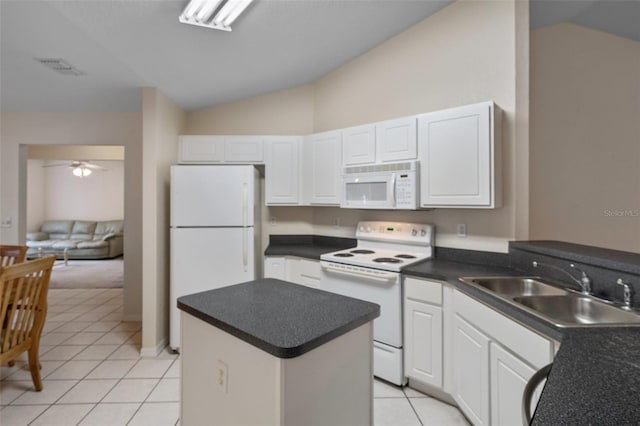 kitchen with white appliances, a kitchen island, vaulted ceiling, a sink, and light tile patterned flooring