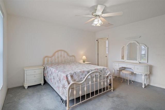 carpeted bedroom with ceiling fan and baseboards