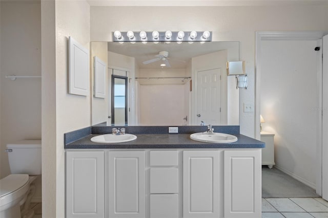 bathroom featuring toilet, a ceiling fan, a sink, and tile patterned floors