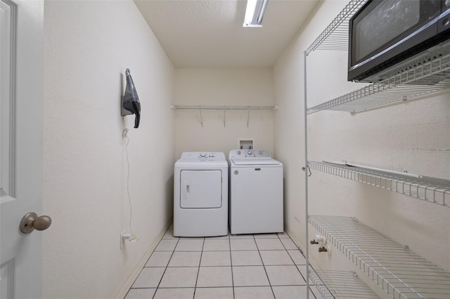 clothes washing area with laundry area, light tile patterned flooring, and independent washer and dryer