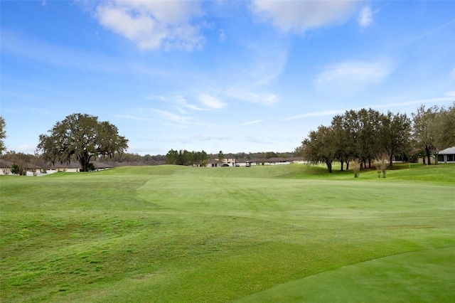 view of home's community featuring view of golf course and a lawn