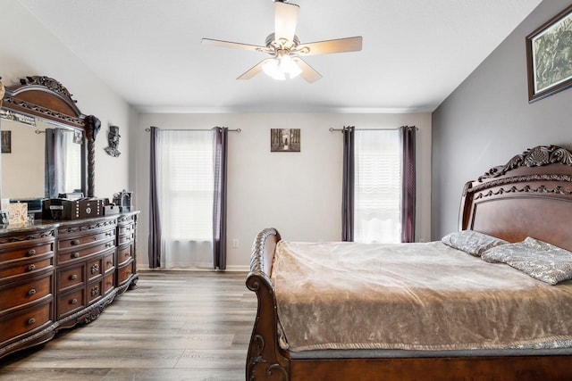 bedroom with ceiling fan, baseboards, and wood finished floors