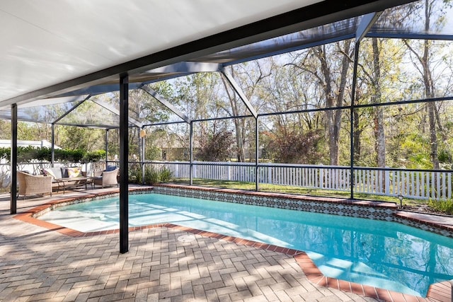 view of swimming pool featuring glass enclosure, a fenced backyard, outdoor lounge area, a fenced in pool, and a patio area