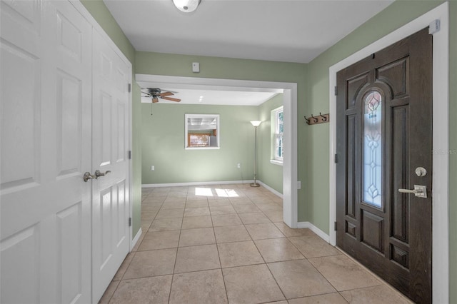 entrance foyer with ceiling fan, light tile patterned flooring, and baseboards