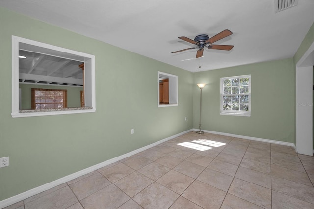 unfurnished room with a ceiling fan, tile patterned flooring, visible vents, and baseboards