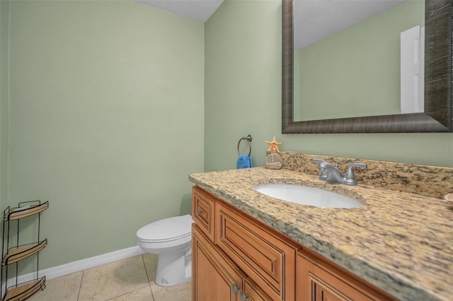 bathroom featuring vanity, tile patterned flooring, toilet, and baseboards