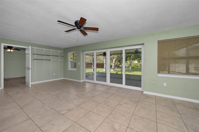 interior space featuring a textured ceiling, a ceiling fan, and light tile patterned flooring