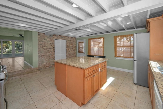 kitchen with freestanding refrigerator, beam ceiling, a center island, and dishwasher