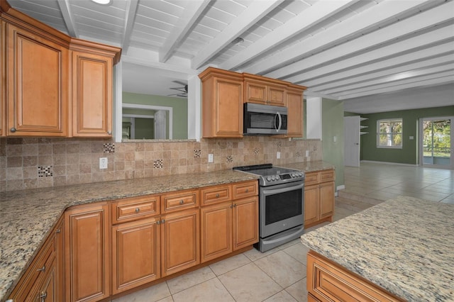 kitchen with light tile patterned floors, stainless steel appliances, tasteful backsplash, and beam ceiling