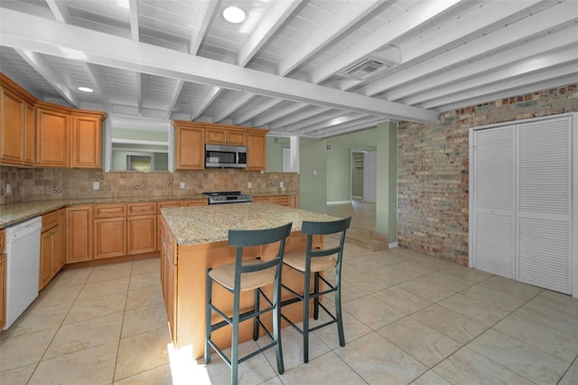 kitchen with brick wall, beamed ceiling, dishwasher, tasteful backsplash, and stainless steel microwave