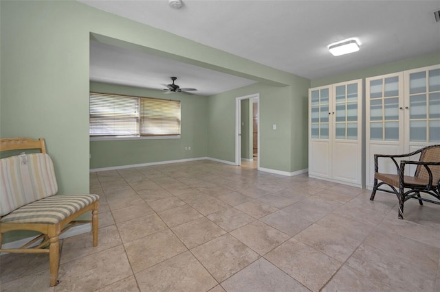 living area featuring a ceiling fan, visible vents, baseboards, and light tile patterned flooring