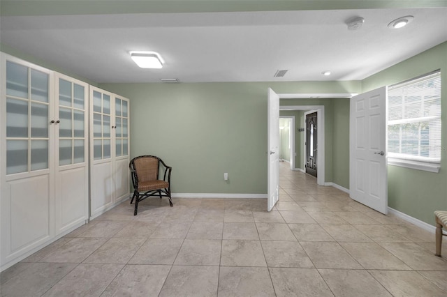 unfurnished room with light tile patterned floors, visible vents, and baseboards