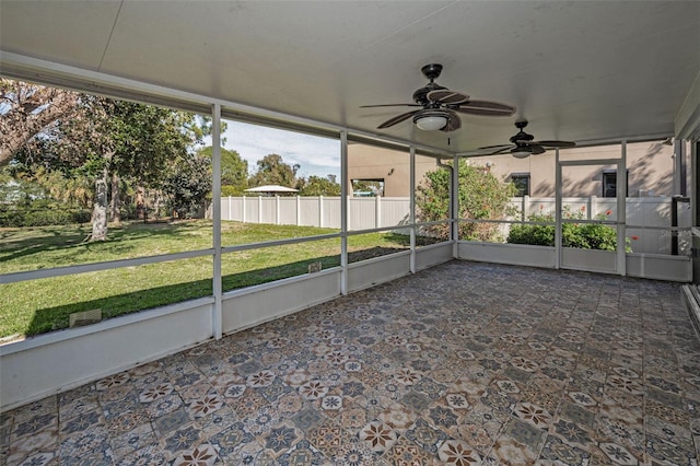 unfurnished sunroom featuring ceiling fan