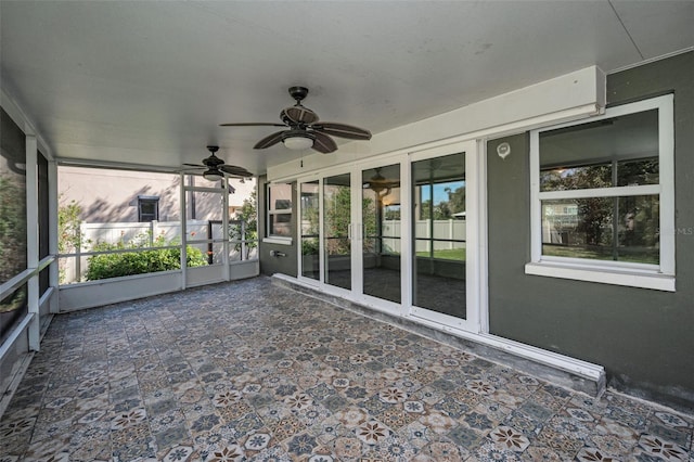 unfurnished sunroom featuring a ceiling fan